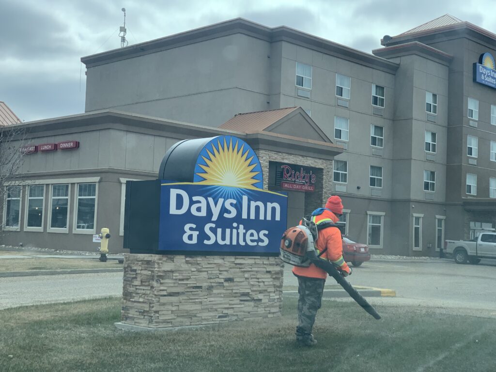 A Man Working Near at the Signage of Days Inn and Suites