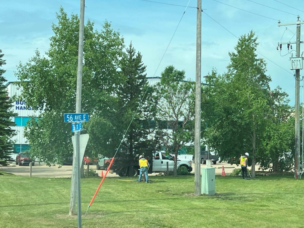Several People Standing Together by a Power Pole